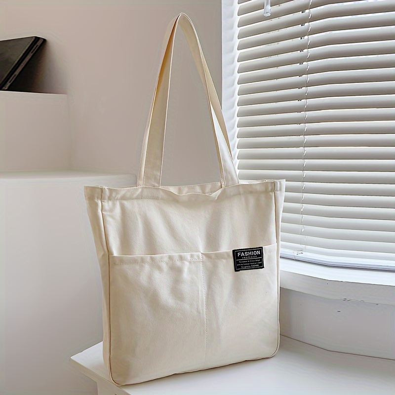 Large Capacity Tote Bag, College Style Durable Fabric Bag With Fashion Label, Shoulder Bag With Pocket For Work And Commuting
Large Capacity Tote Bag, College Style Durable Fabric Bag With Fashion Label, Shoulder Bag With Pocket For Work And Commuting