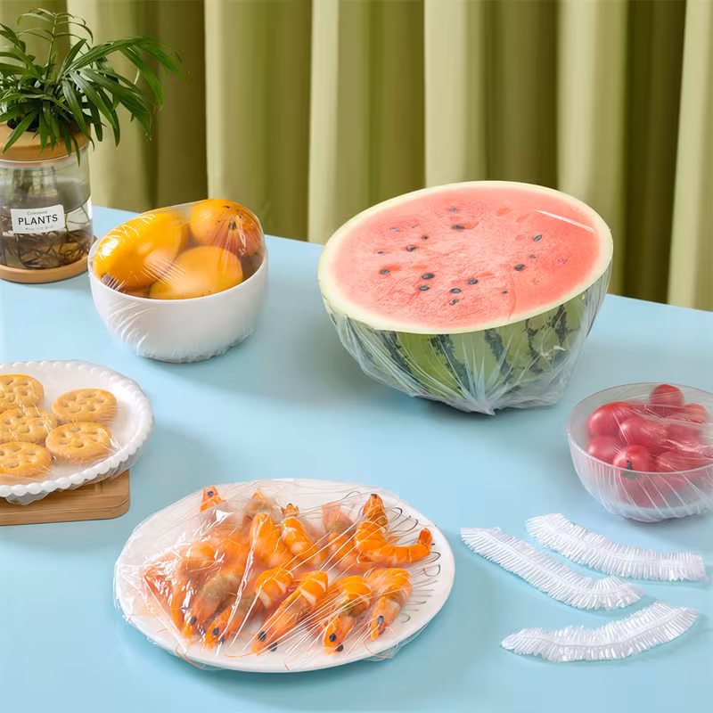 Mesa posta com diversos alimentos cobertos pelas tampas plásticas descartáveis