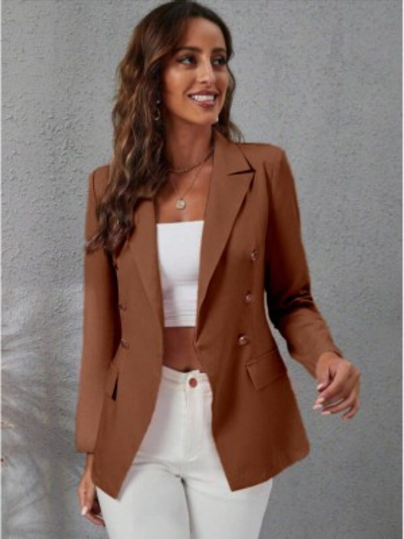 Blazer marrom com botões dourados, vista frontal, modelo feminino usando com blusa branca e calça jeans