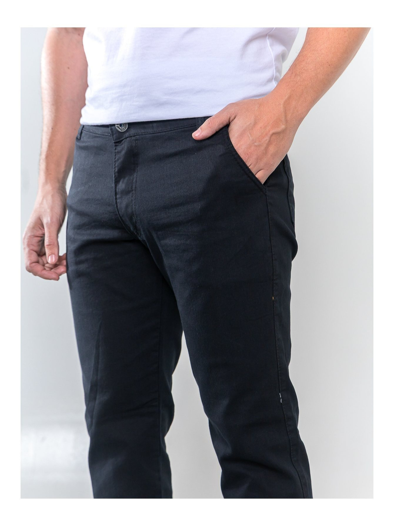 Vista frontal em close da calca sarja masculina preta com modelo vestindo camiseta branca