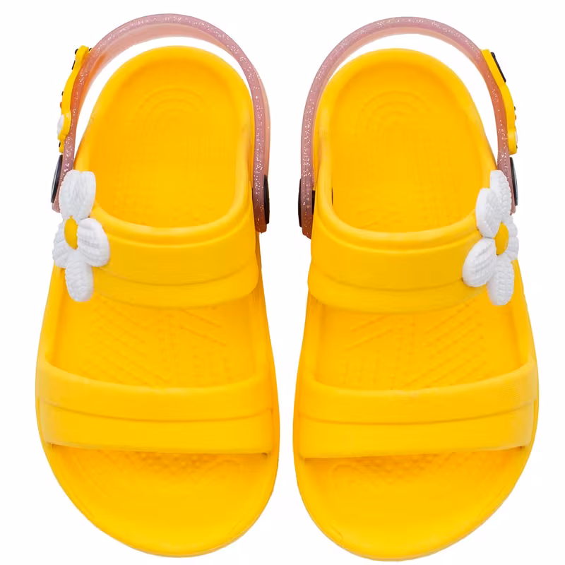 Par de sandalias infantis amarelas com detalhes de flores brancas e tiras traseiras transparentes