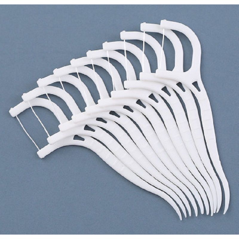 Vários palitos com fio dental brancos dispostos em formato de leque sobre um fundo azul, mostrando o arco com o fio e o cabo curvado.