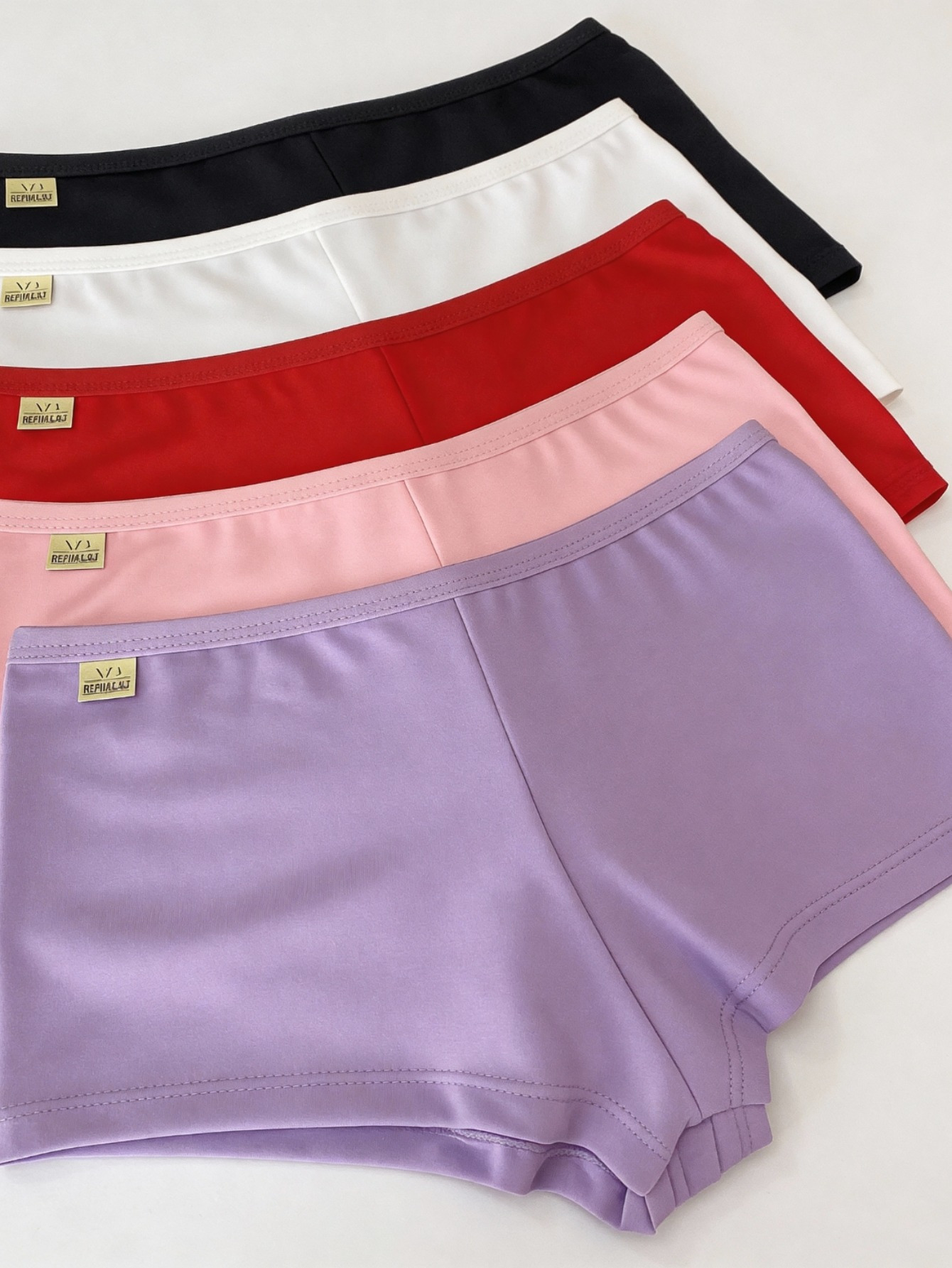 Conjunto de 5 calcinhas estilo shortinho em microfibra expostas sobre uma superfície branca