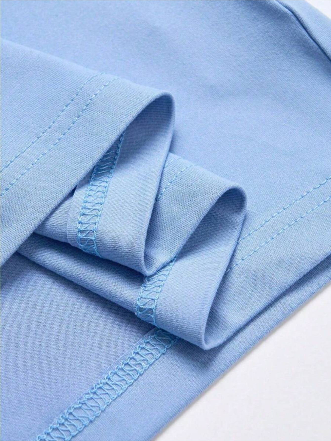 Detalhe macro da costura reforçada e textura do tecido de algodão na cor azul