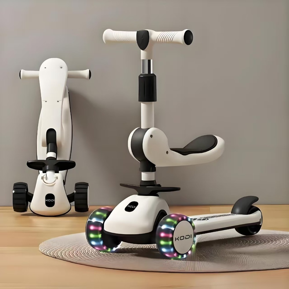 Dois patinetes KODI brancos com rodas iluminadas posicionados em um ambiente interno sobre um tapete