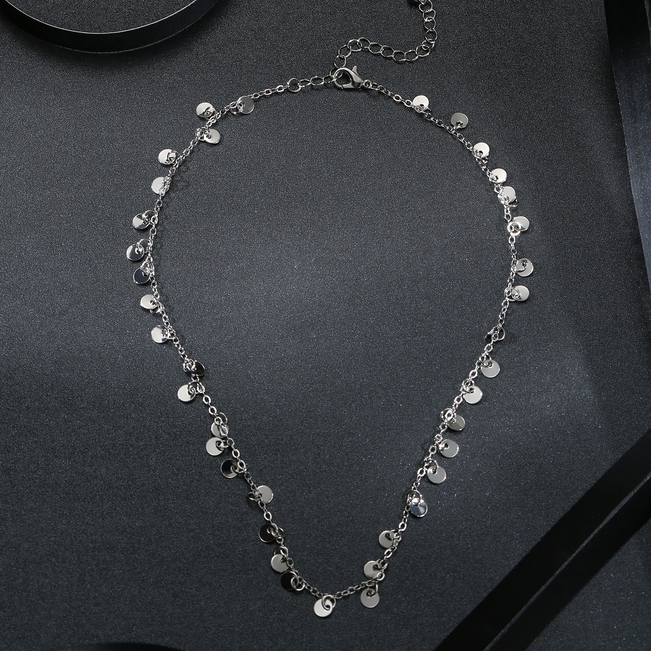 A Necklace With A Silvery Metal Circular Pendant