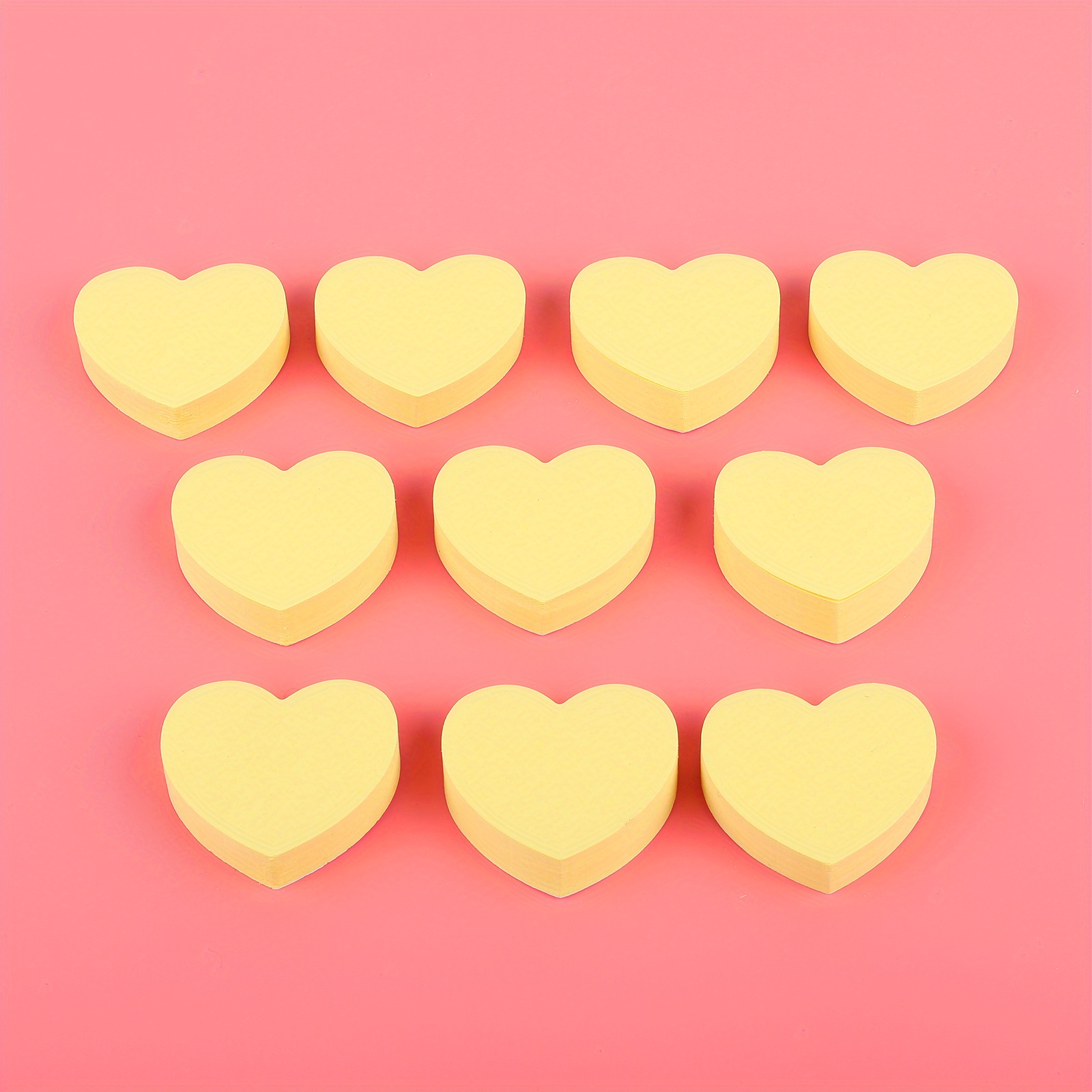 some heart-shaped sticky notes of different colors with a blank