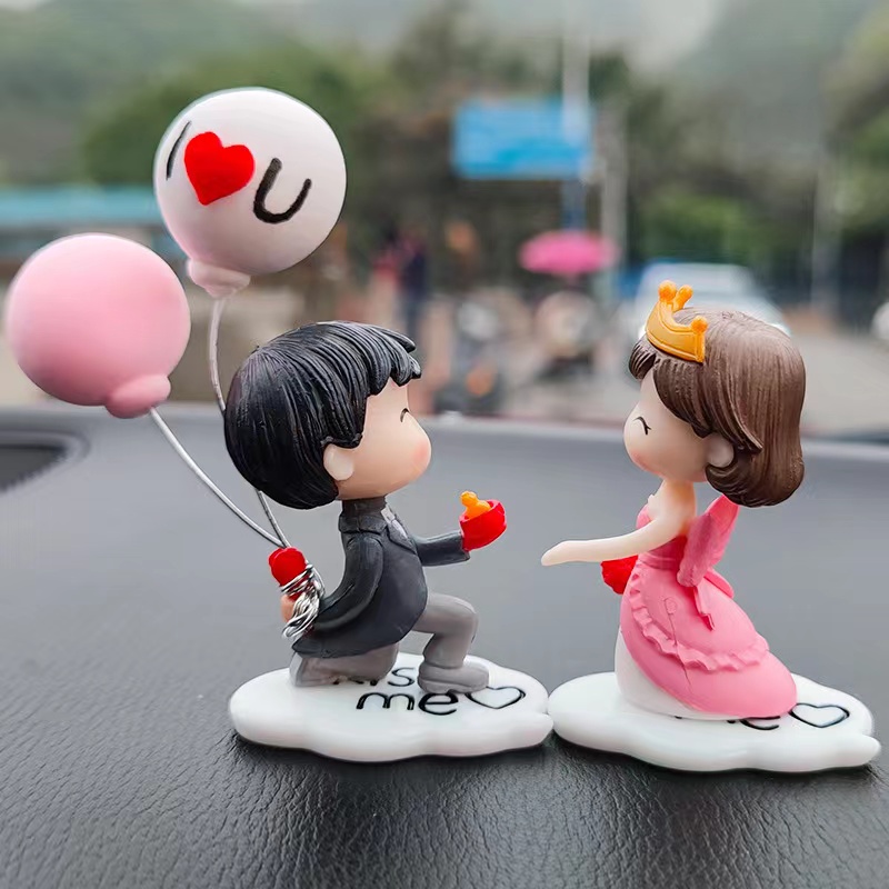 Jolies figurines de couple tenant des ballons pour la décoration