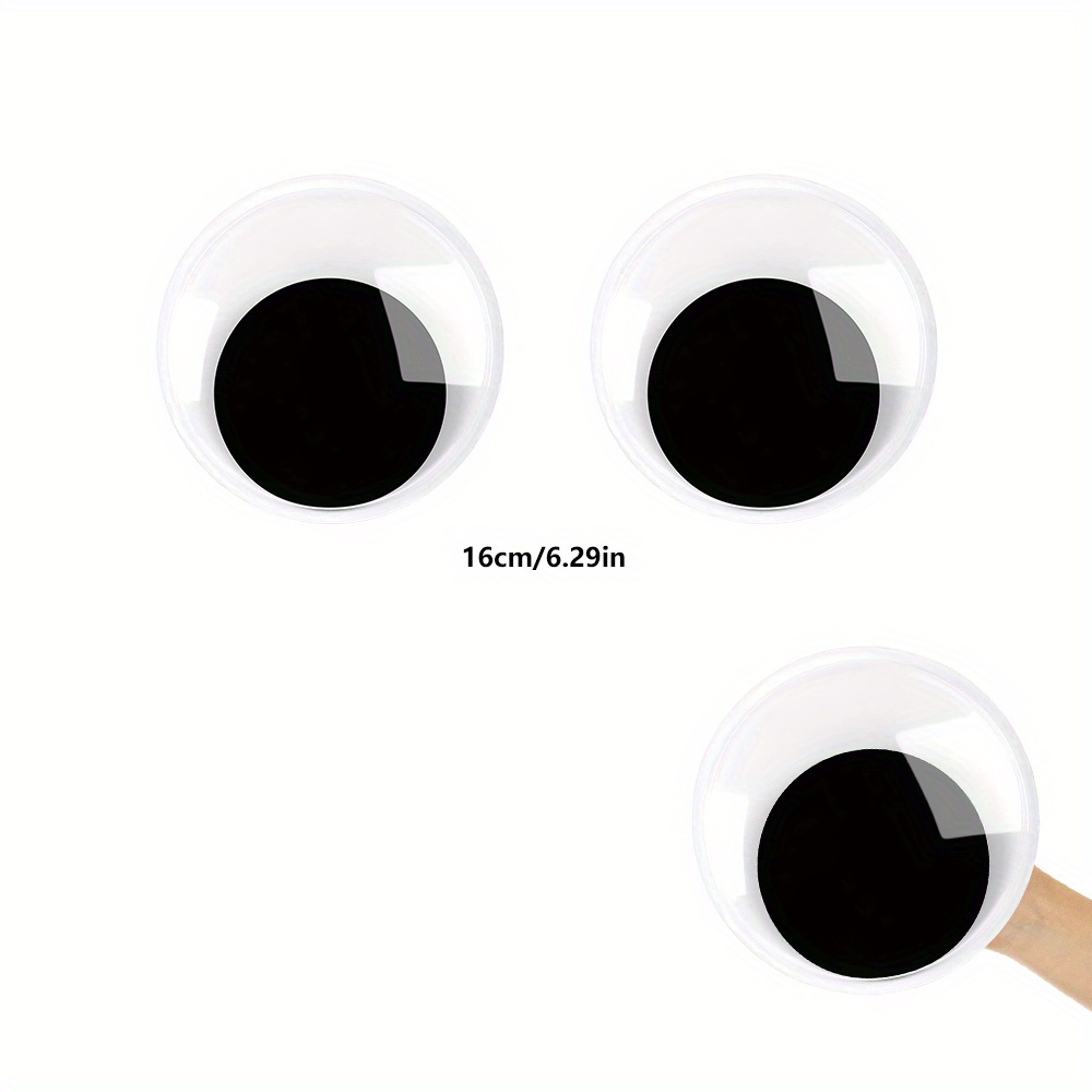 Googly eyes are small plastic craft supplies used to imitate eyeballs  isolated on black background. Stock Photo