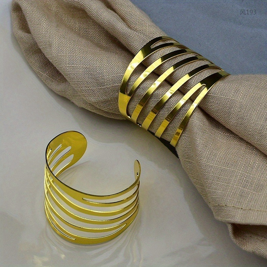 A Set Of 6 Elegant Golden Napkin Rings With A Slanted Design, Featuring A Simple And Stylish Circular Opening, Perfect For High-end Hotel Dining Tables And Wholesale Napkin Ring Purchases.