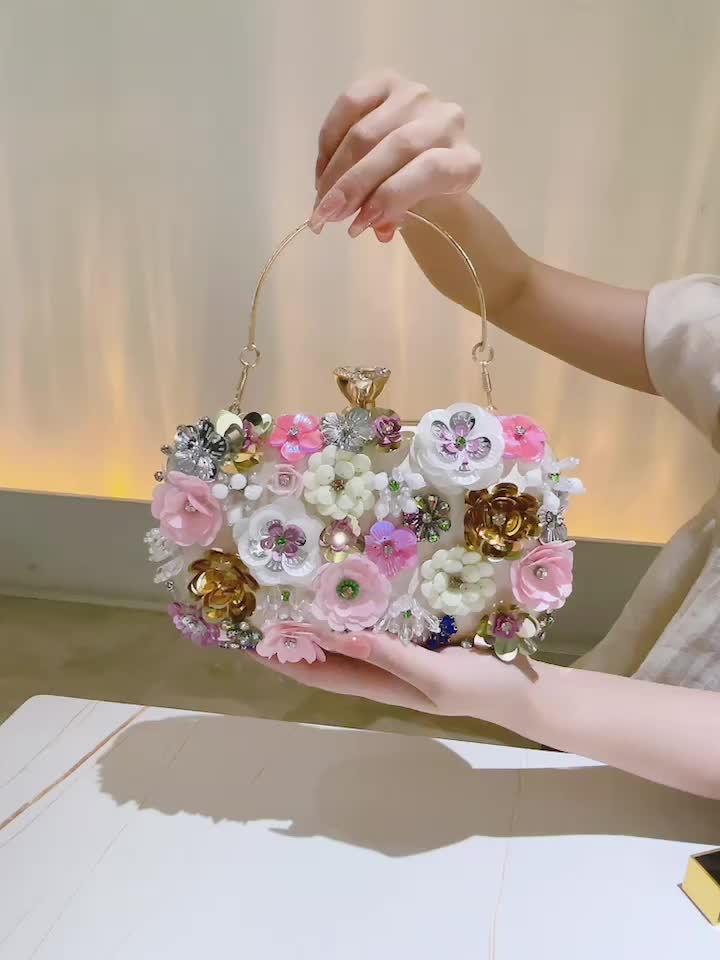 Evening bag made of glass breathing, with three-embroidered silver-colored  silk flowers on either side. Evening bag made of glass batteries in a  shield form, along which the entire edge has a pleated