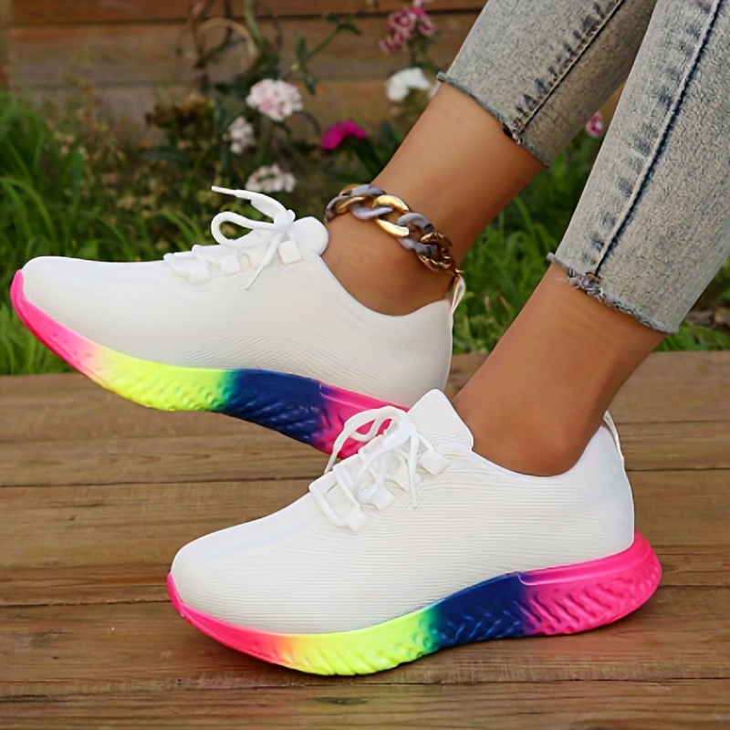 Un par de zapatillas para correr para mujer con zapatos coloridos sobre una  superficie reflectante.