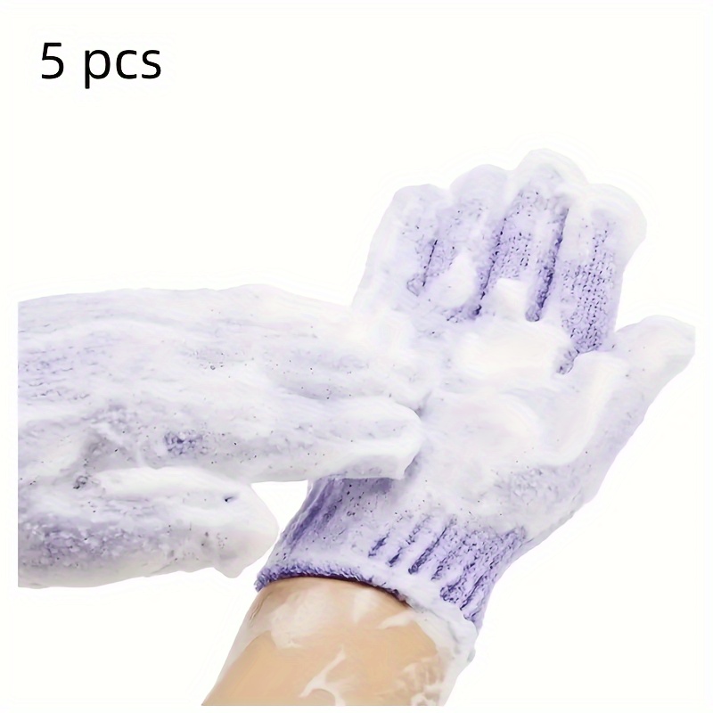 Después de una ducha, una niña envuelta en una toalla usa guantes  cosméticos para hidratar la piel de sus manos y pies. tendencias cosméticas  para el cuidado corporal en casa.