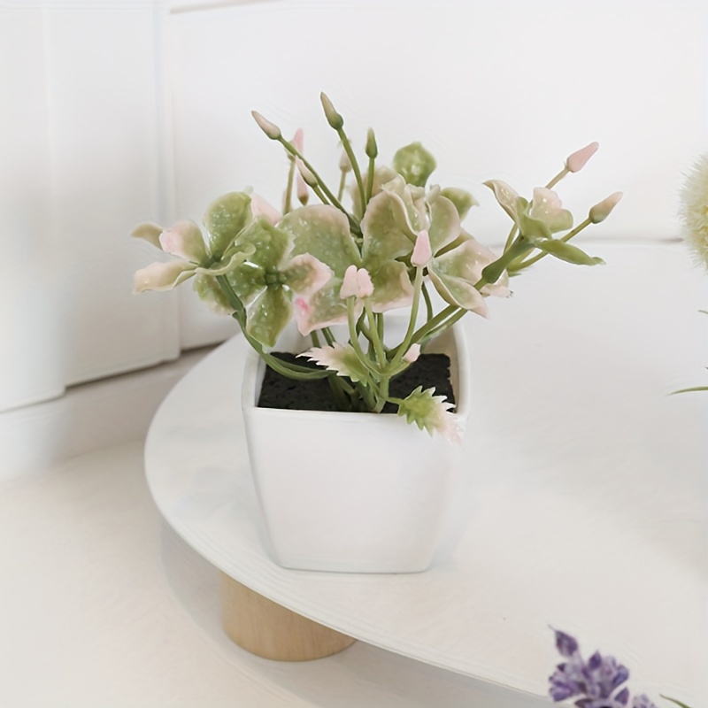 Flores artificiales con pequeño jarrón de cerámica, hortensias