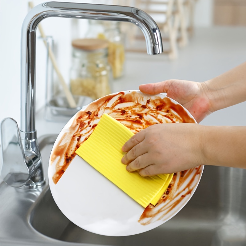 Esponja para lavar platos, trapo de cocina y estropajo sobre fondo de  madera