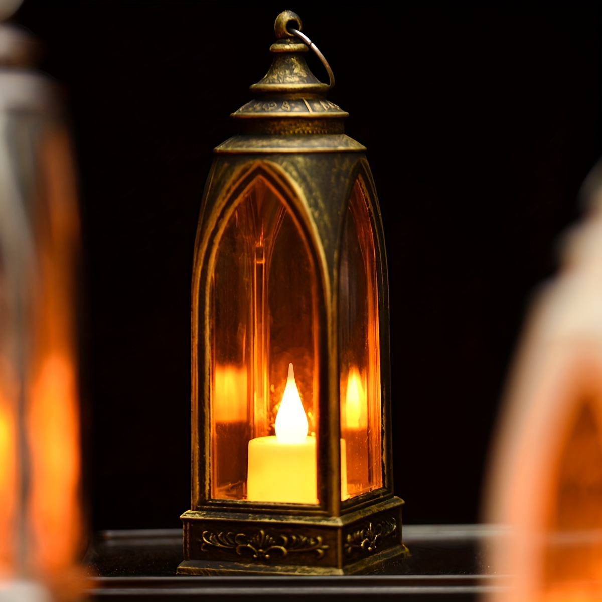 collapsible camping candle lantern burning in darkness on a rustic