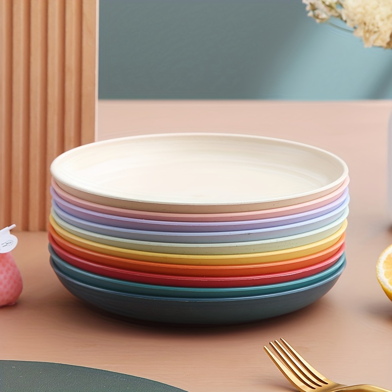 A set of plastic utensils. Dishes made of colorful plastic for picnic or  camping. A set of plates, mugs and cutlery for eating in nature. Stock  Photo