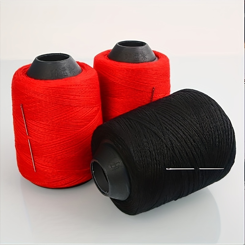 Black Thread With A Needle And A Spool Of Threads On A White