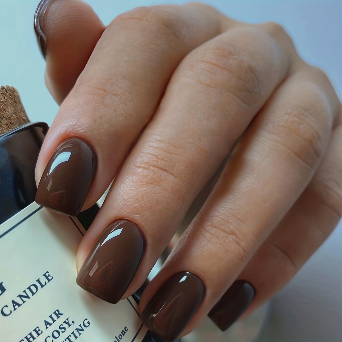 Premium Photo | Female hand with brown nail design. brown nail polish  manicure. woman hand on light brown fabric bac