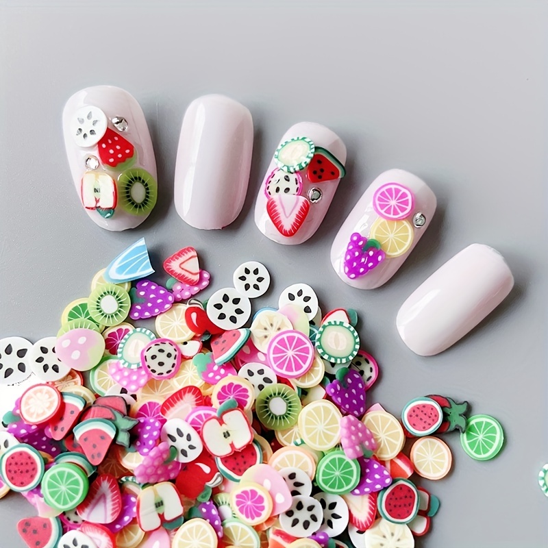 

Lot de 1000 pièces de décorations pour ongles en polymère en de fruits, plumes, fleurs, animaux et variés pour des ongles