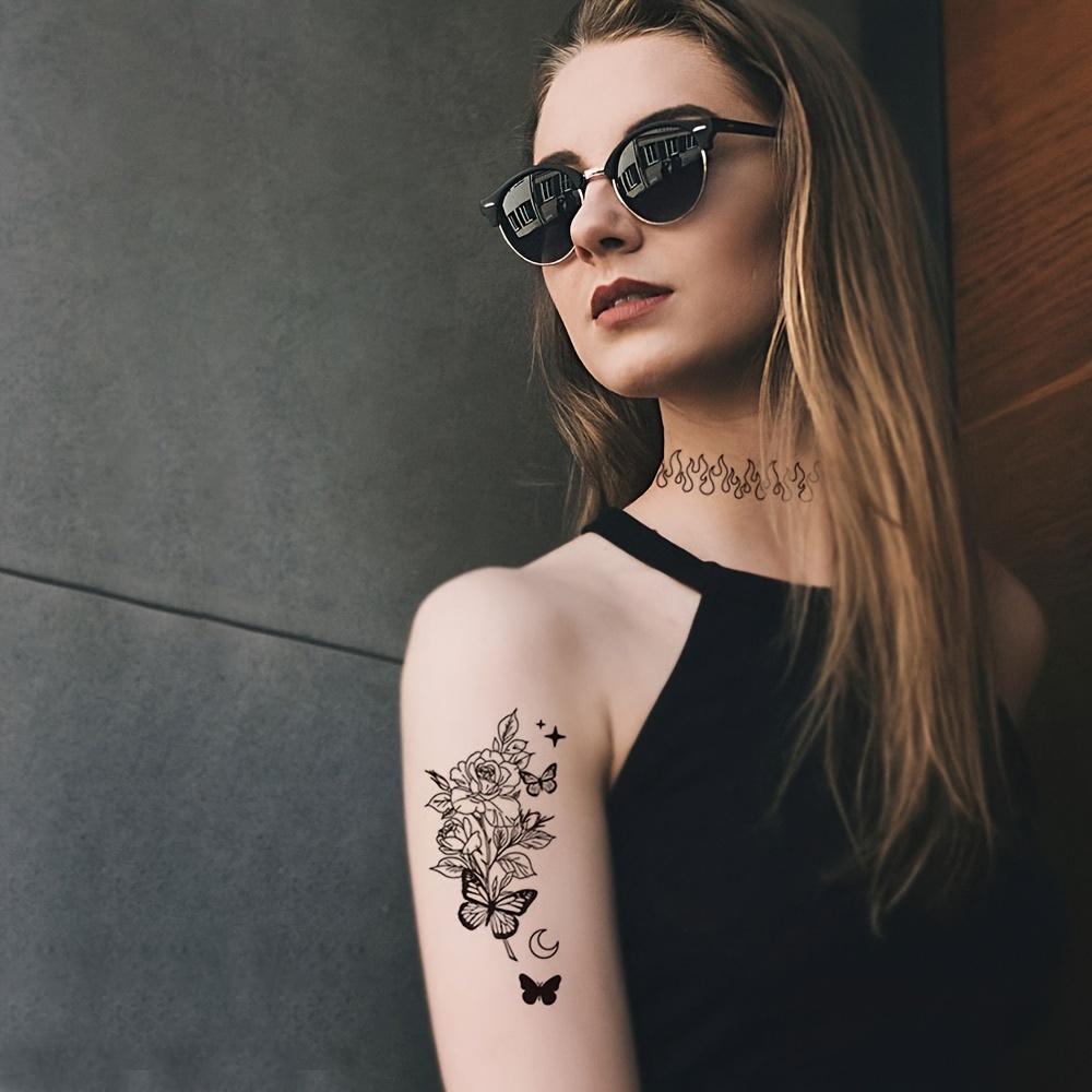 Tatuajes en el brazo femenino de tinta negra y roja Fotografía de