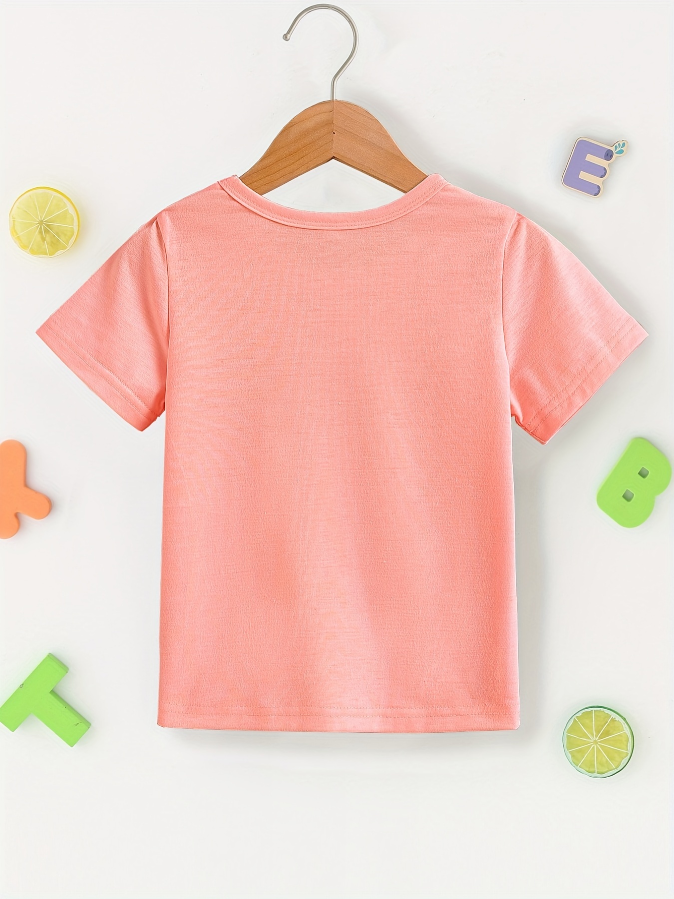 Una niña con una camiseta naranja con el número 1 en la camiseta