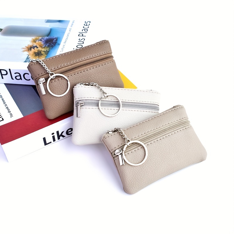 a small wallet with a keychain that holds   in a mini coin purse