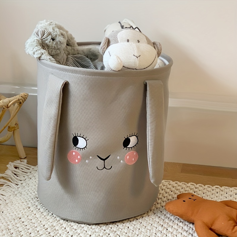 Adorable bebé escondido en un cesto de ropa sucia
