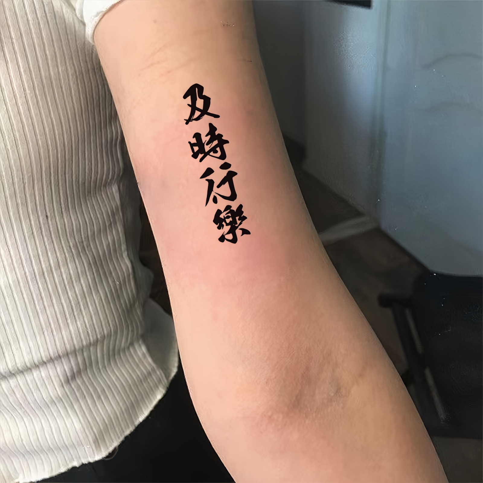 Chinese characters tattoo located on the inner arm.