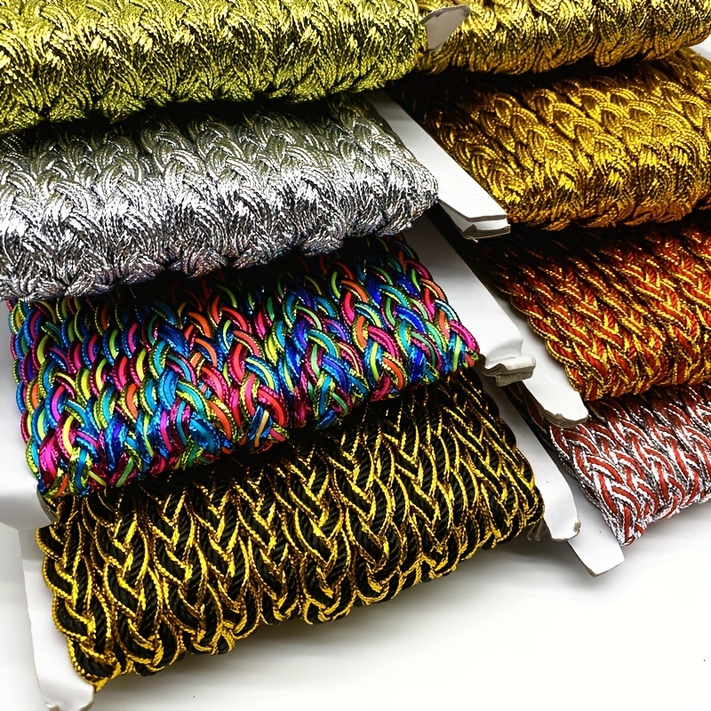 Hilos de algodón bordado multicolores y plumas de avestruz esponjosas sobre  una almohada con lentejuelas doradas