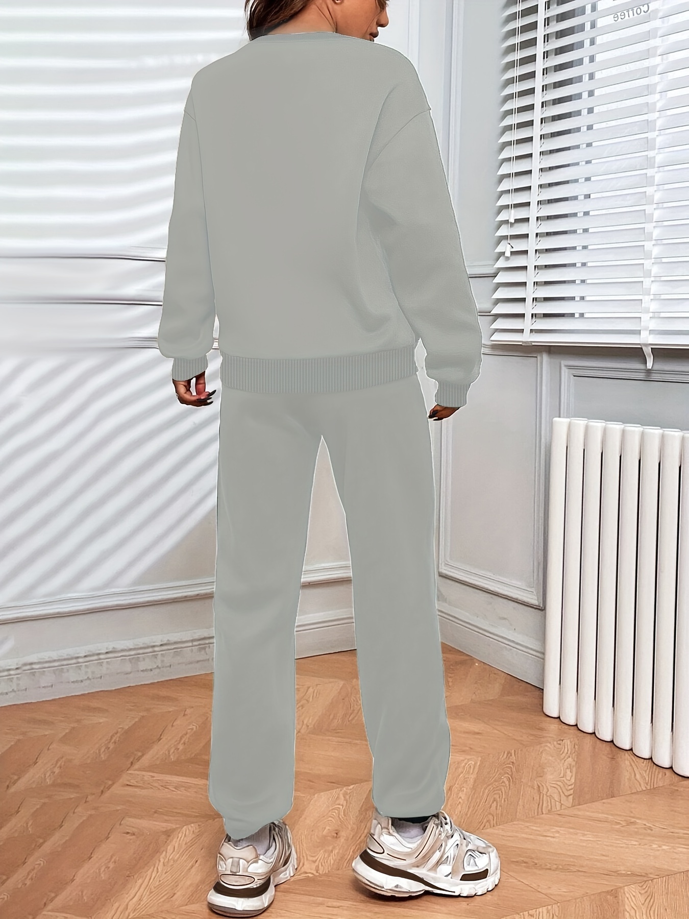 Model wearing the complete solid color loose sweatshirt and drawstring pants set