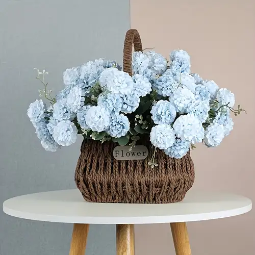 Flores artificiales con pequeño jarrón de cerámica, hortensias