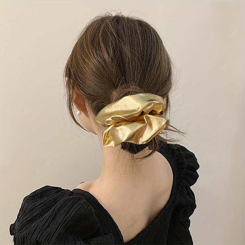 

A Stylish Silvery Leather Large Hair Scrunchie With A , A Luxurious When Tied Into A Ponytail.