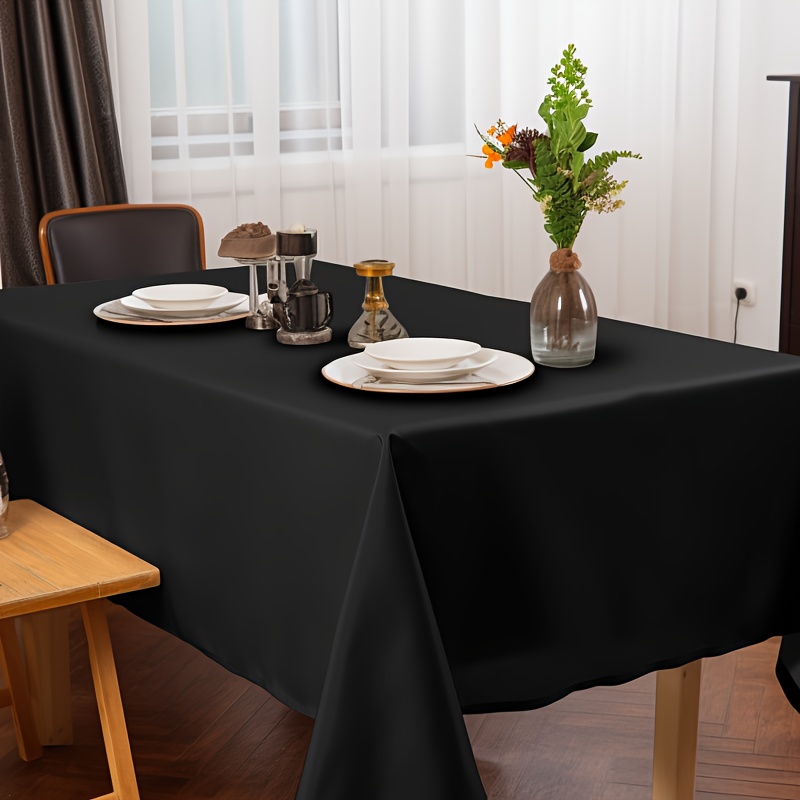 Mesa elegante con mantelería y vajilla negra en contraste con