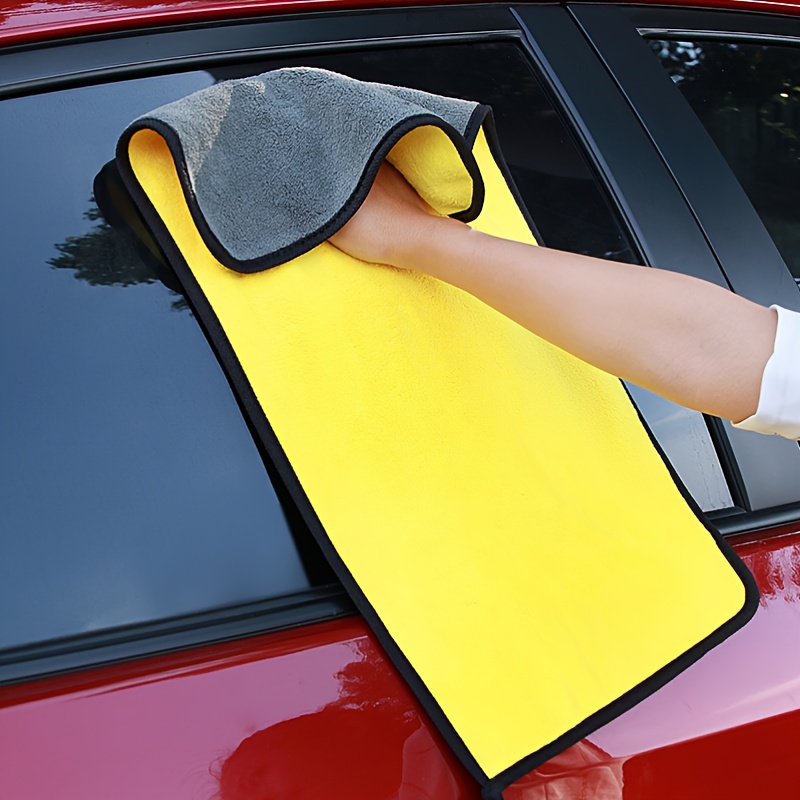 Uomo con guanti di protezione pulizia cruscotto auto con panno in