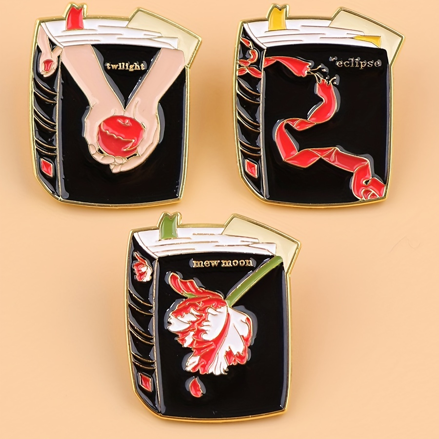

twilight" Enamel Pin: A Black And Gold Charm Featuring Bella And Edward's Hands Holding A Red