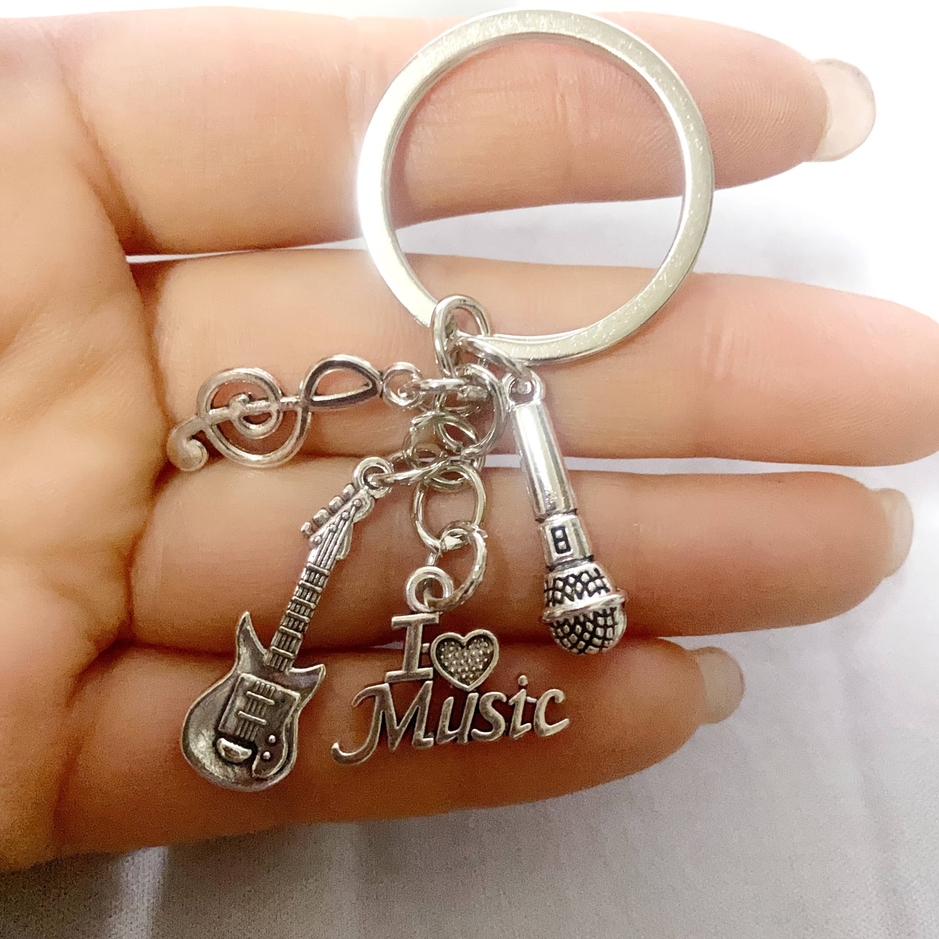 A Gift For A Music Enthusiast: A Keychain With A Microphone, Guitar, And Musical Note Charms. A Stylish Accessory, Perfect For Hanging On Wallets Or Cars.