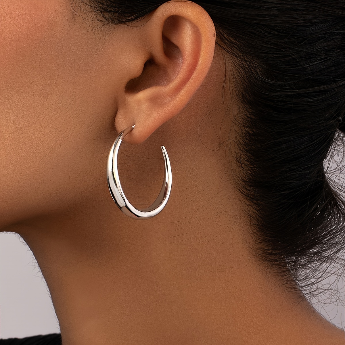 

Une paire de boucles d'oreilles élégantes et minimalistes en de C en métal pour femmes, adaptées à un et aux fêtes.