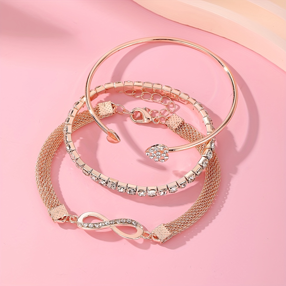 A Set of Three Women'S Bracelets And Bangles Featuring Wireless Symbols And Heart Designs Adorned with Rhinestones.