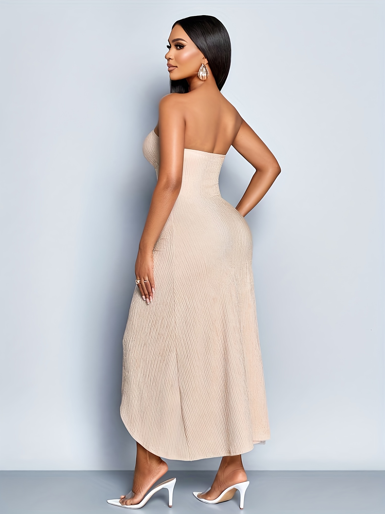 A Sleeveless, Strapless Dress with Hollow Metal Button Decorations, Featuring a Front Split And Made from Textured Fabric in a Light Color, Perfect for Casual Vacation Wear