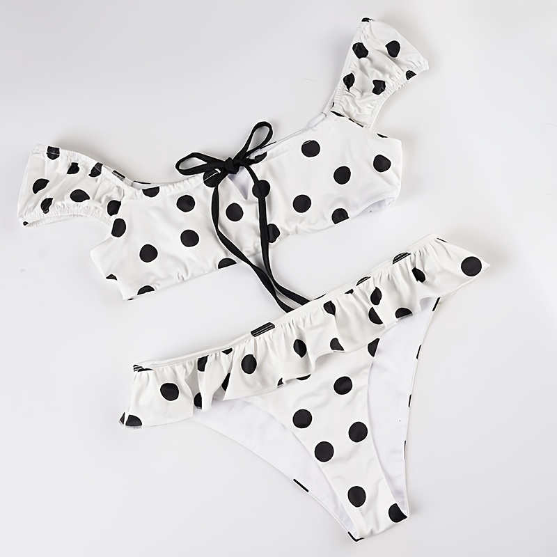 A Beach Vacation Outfit Featuring a Color-Blocked Polka Dot Bikini Set, with a Sexy Tie-Front Crop Top And Ruffled Shorts, Perfect for Seaside Holidays