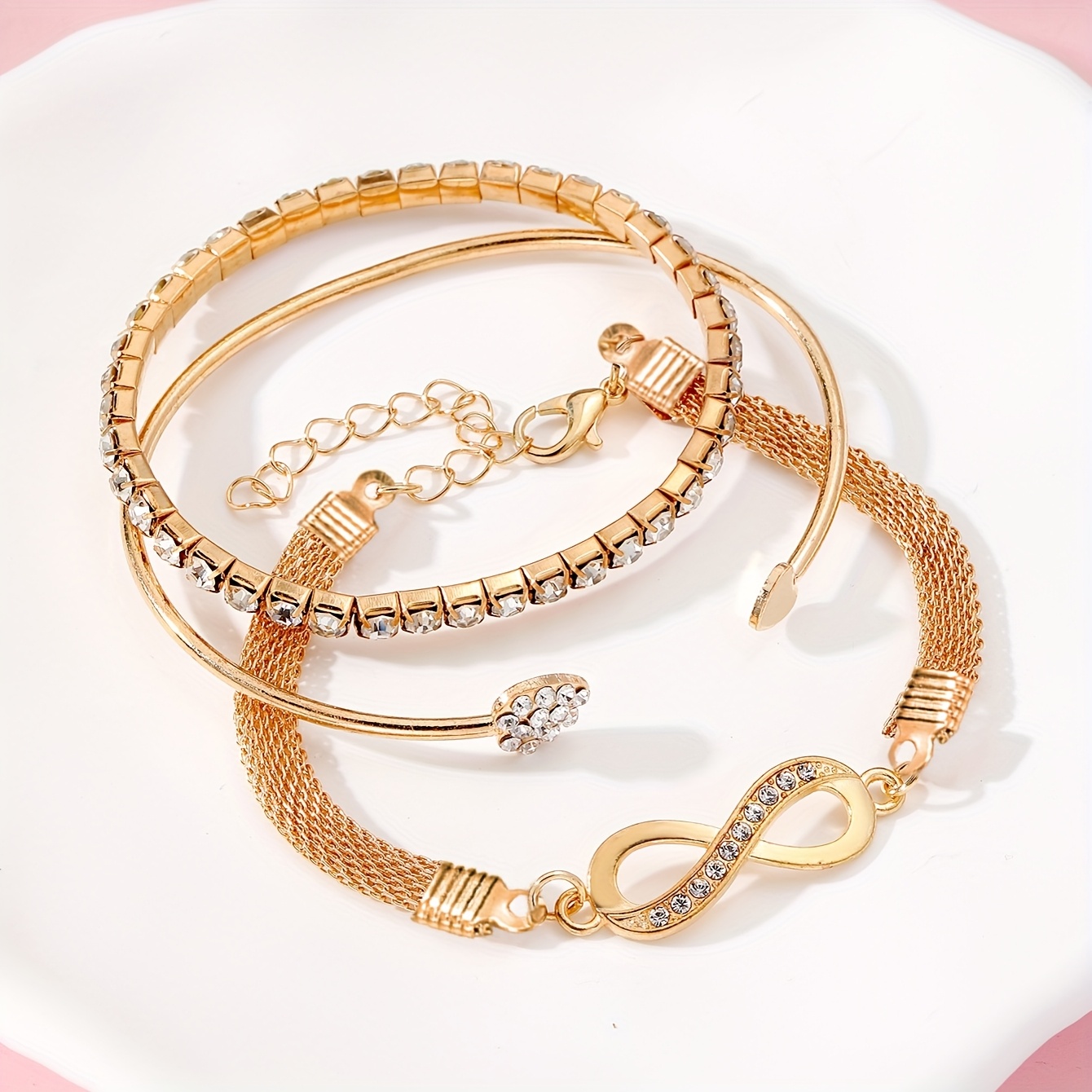 A Set of Three Women'S Bracelets And Bangles Featuring Wireless Symbols And Heart Designs Adorned with Rhinestones.