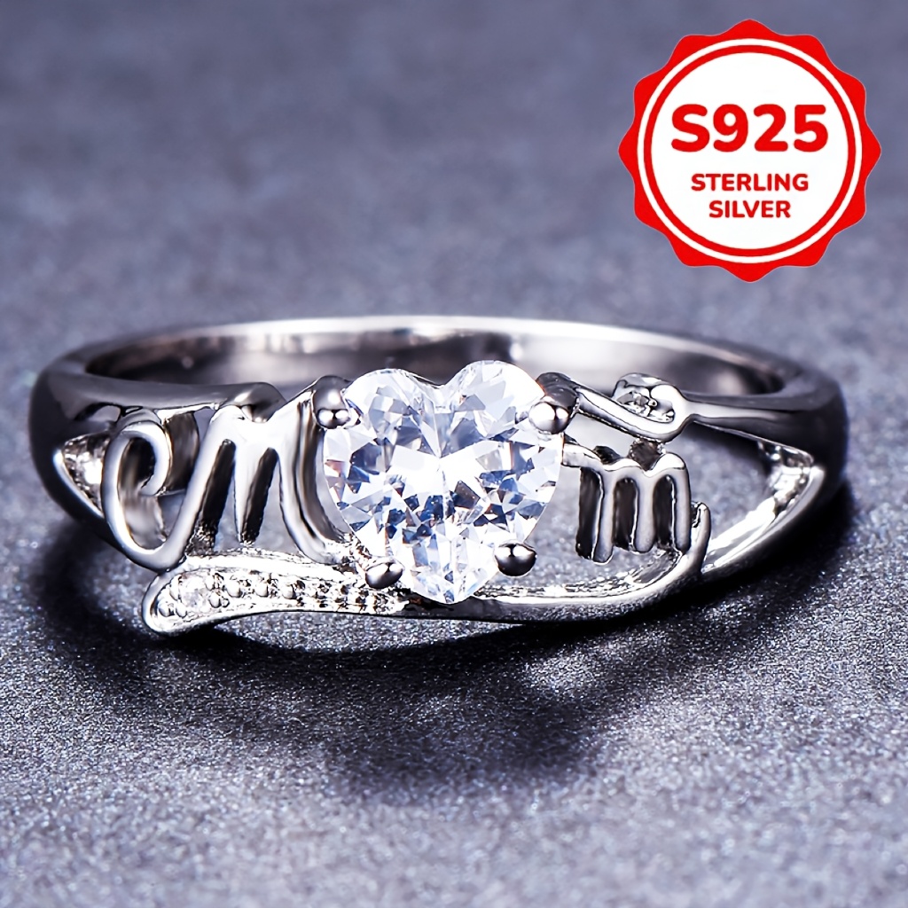 

A Beautiful Mom Letter Ring With A Heart-shaped Cut Synthetic Cubic Zirconia Set In A 4- Setting, Perfect As A Day Gift Accessory For Women.