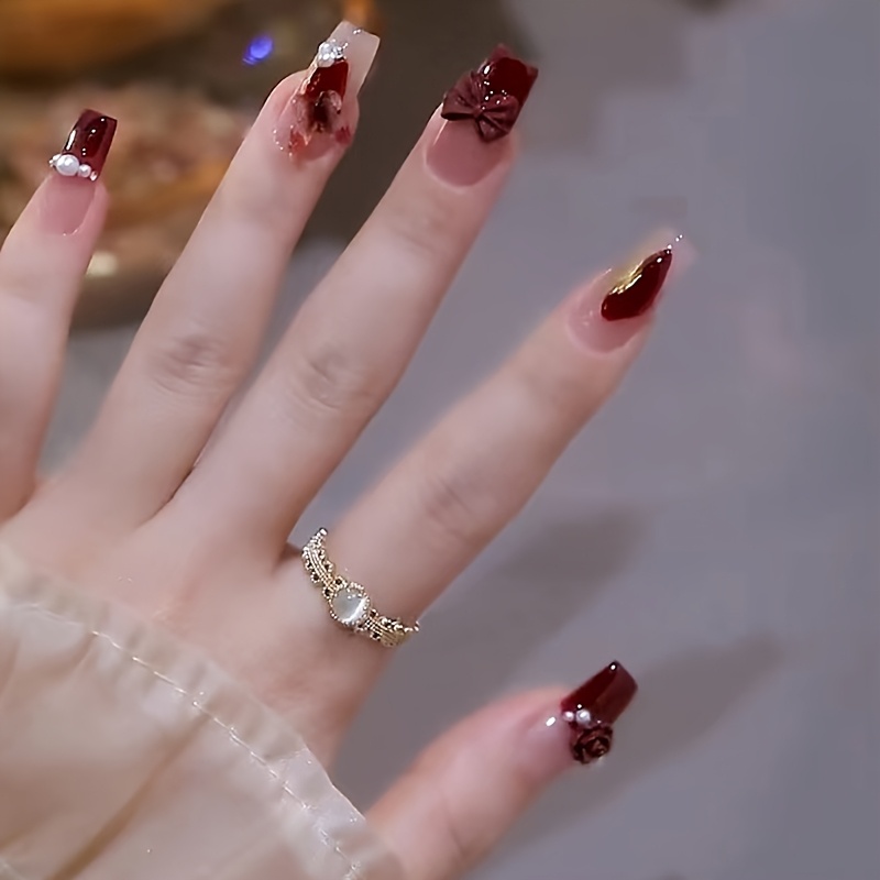 a set of 24 festive red   nails with bow designs in a   medium length with a pearlescent   gradient and heart decorations featuring removable sparkling   stickers Product details 1