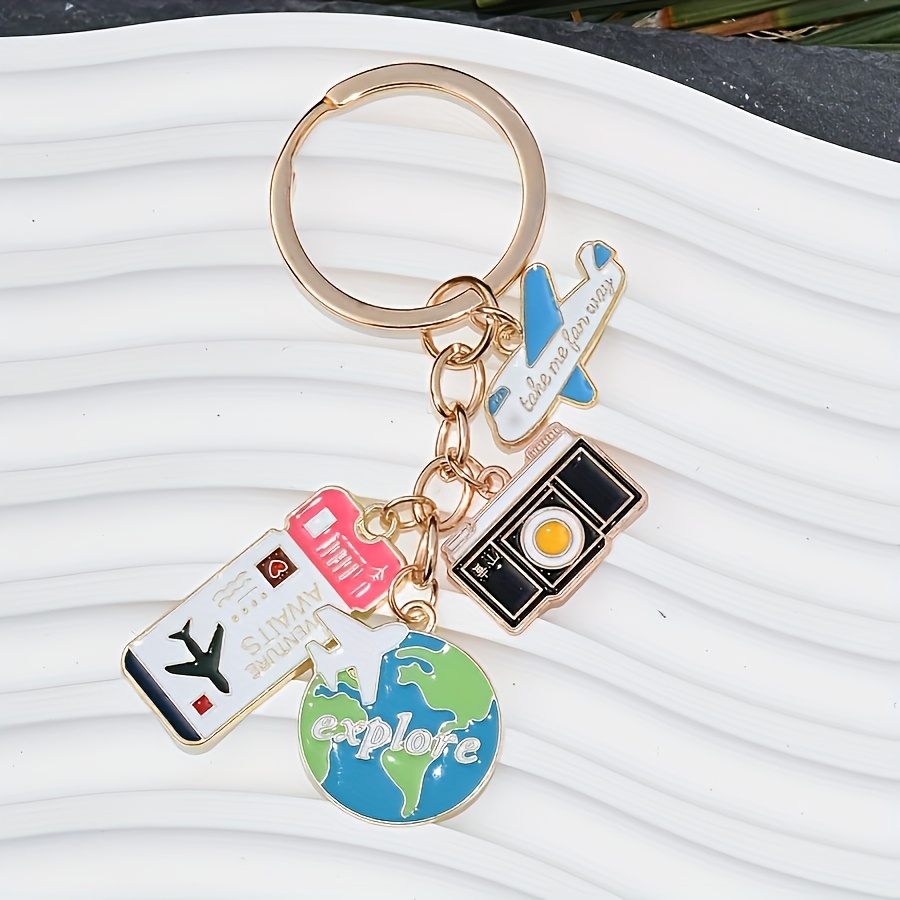 A Travel-themed Keychain Featuring An Airplane, , And A Yellow/oil-painted With A Five-ring Design, Perfect For Bags, Backpacks, And Car Additions, Making It An Ideal Gift For Travel Enthusiasts