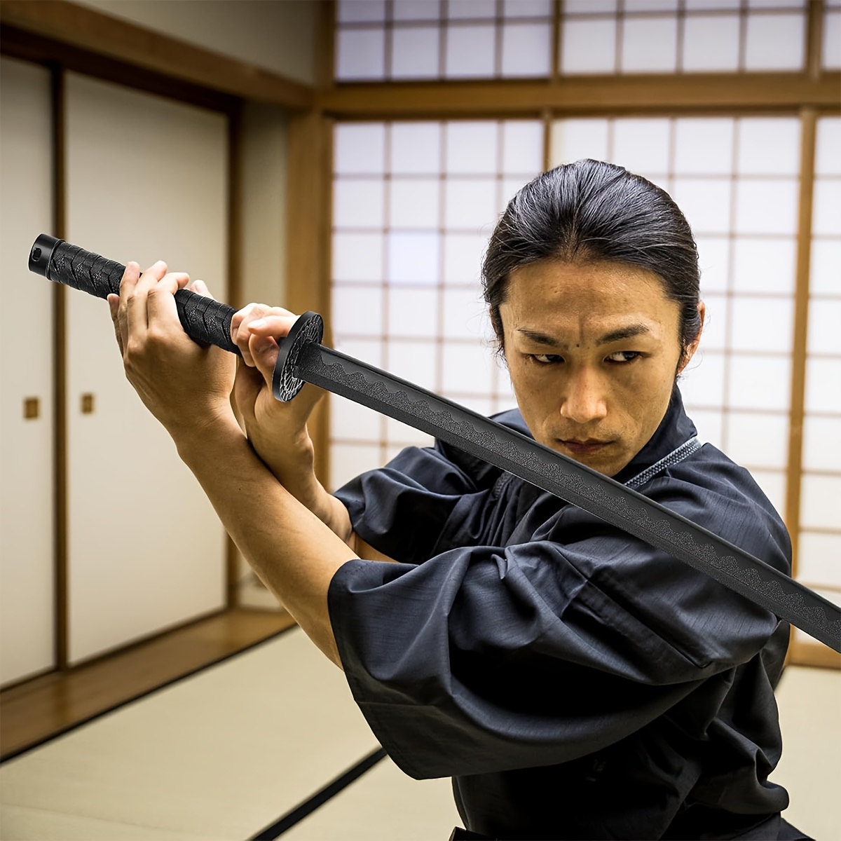 Person in traditional martial arts attire holding a training sword in a room with wooden walls and a window.