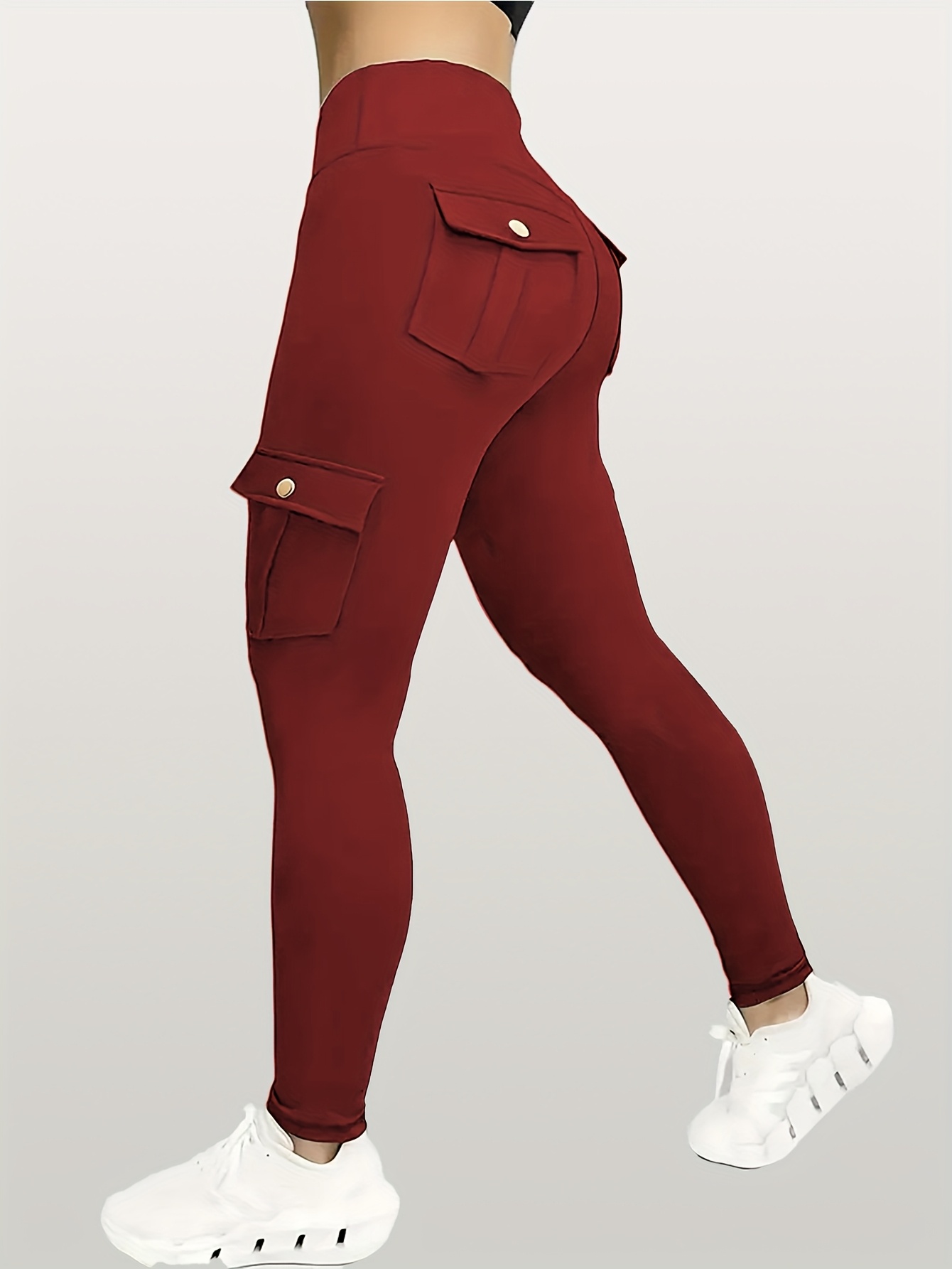 A woman wearing a red yoga leggings sold by 100 Spartans