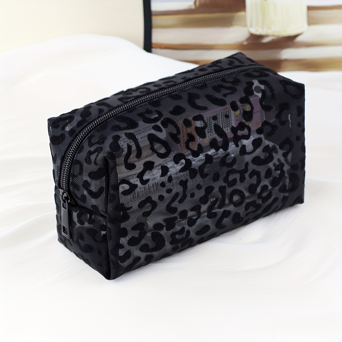 E-shop Eine stilvolle und minimalistische Kosmetiktasche. Diese schwarze, atmungsaktive Make-up-Tasche mit Leopardenmuster verfügt über einen