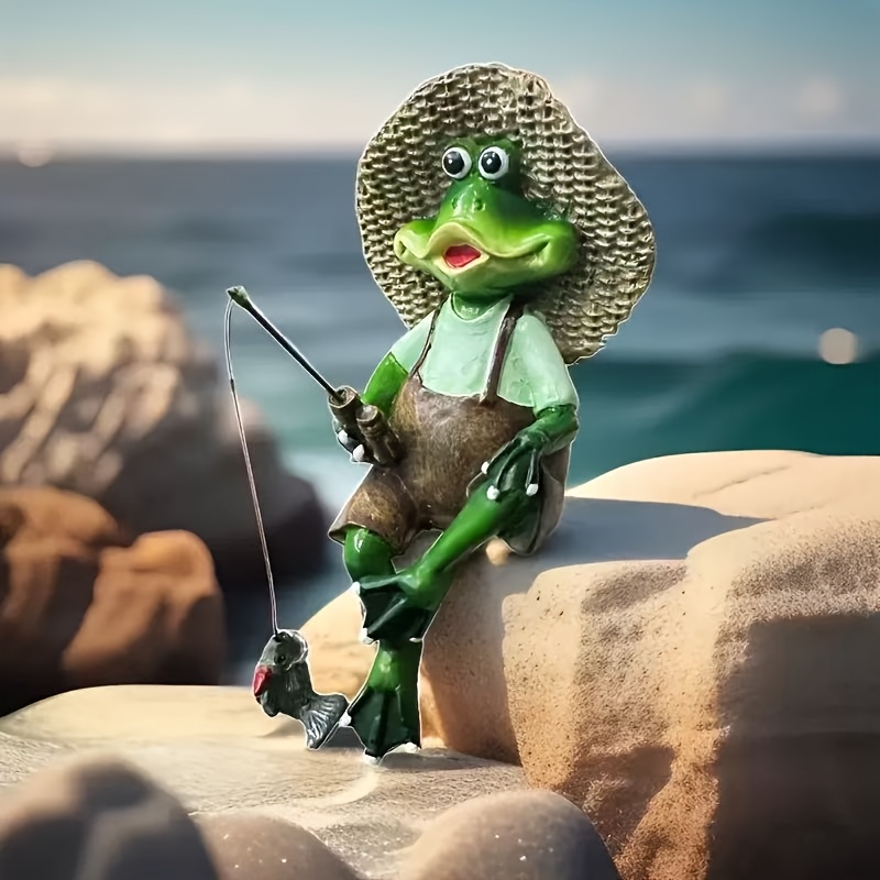 Frog figurine wearing a straw hat and holding a fishing pole