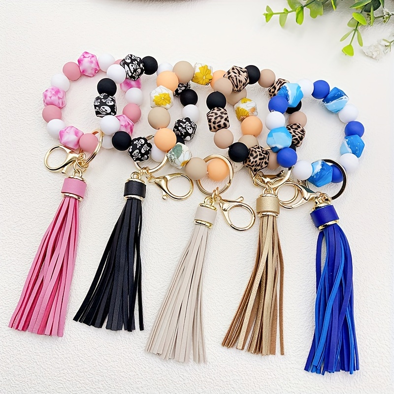 

Porte-clés en silicone avec pompon en cuir PU, tête de mort, fleur, léopard, breloque tendance pour sac à main, cordon pour téléphone portable, cadeau pour femme au quotidien.